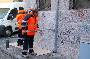 Dos operarios limpian las pintadas en la fachada de un edificio de San Lorenzo (Foto: Cedida)